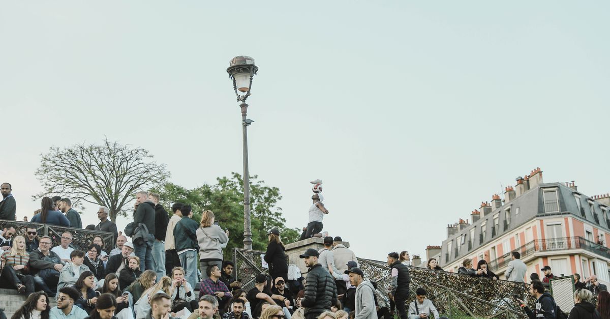 Groupe animé se rassemble sur les marches de Montmartre, Paris, capturant la vie vibrante de la ville.