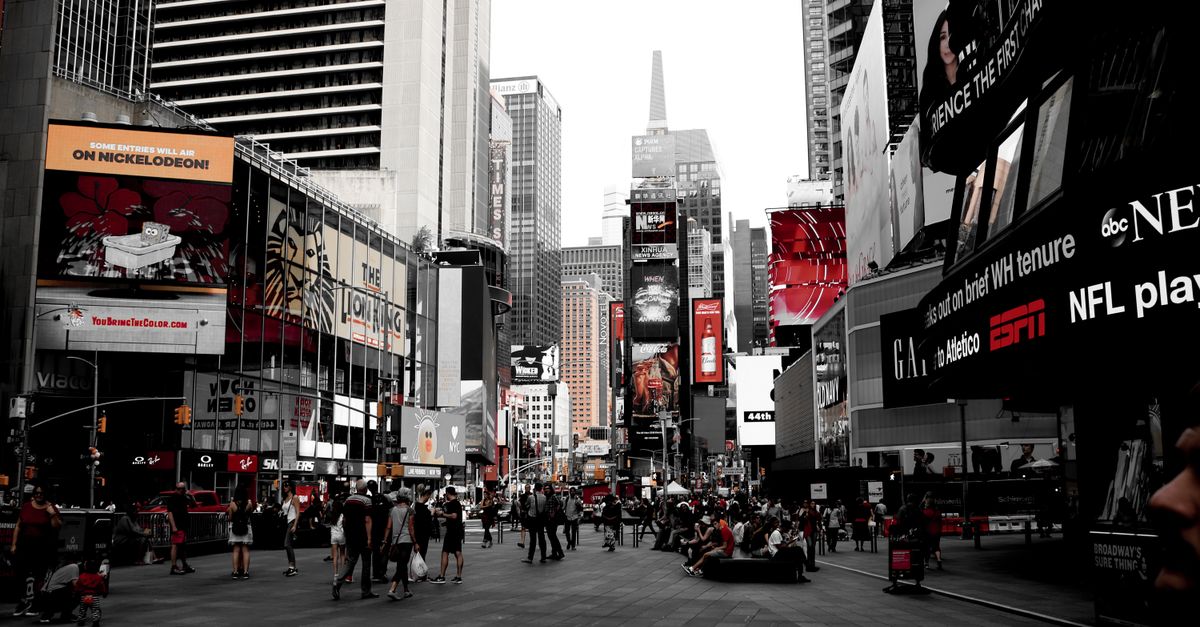 Scène dynamique de Times Square montrant la vie urbaine animée et des panneaux publicitaires emblématiques à New York.