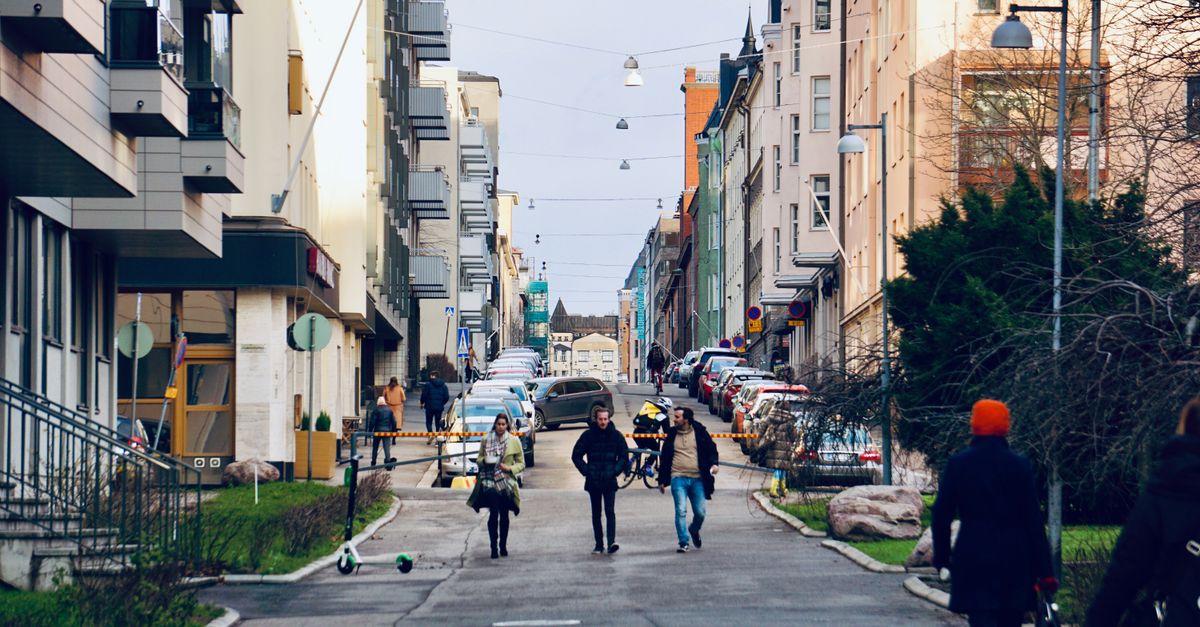 Scène de rue vibrante à Helsinki, Finlande, montrant des piétons parmi une architecture urbaine.